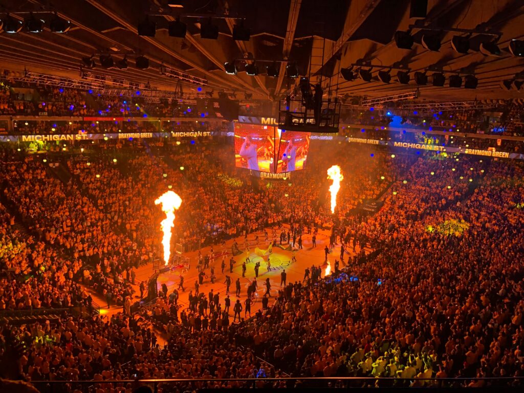 Lively basketball event with a huge crowd and fiery show in Oakland arena, capturing the vibrant sports atmosphere.